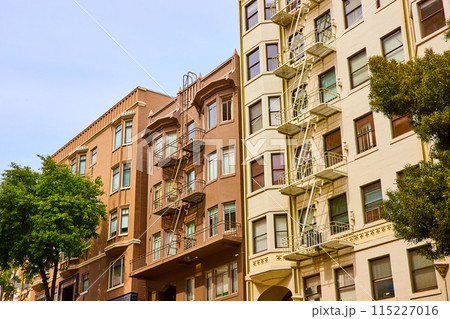 Close together apartment buildings with fire escapes in San Francisco with earthy color tones Close together apartment buildings with fire escapes in San Francisco with earthy color tones 115227016