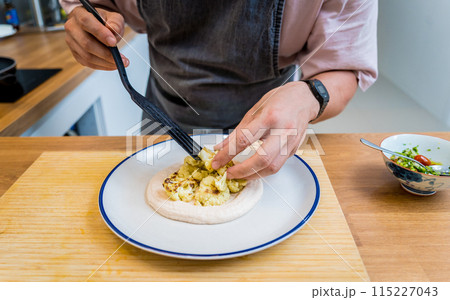 Chef at the kitchen preparing bean porridge with cauliflower and vegetables 115227043