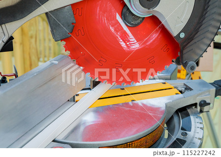 Contractors use circular saws to cut wooden moldings before they are installed 115227242