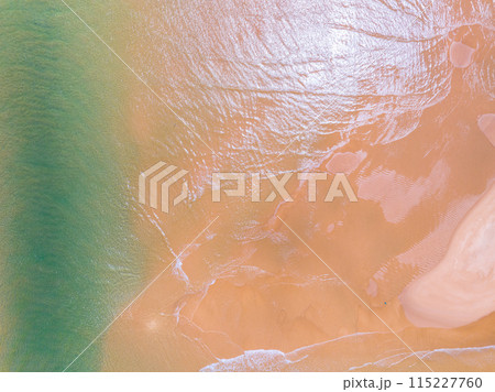 Aerial view of sea crashing waves White foaming waves on beach sand,Top view beach sea surface, Nature sea beach sand background Aerial view of sea crashing waves White foaming waves on beach sand,Top view beach sea surface, Nature sea beach sand background 115227760