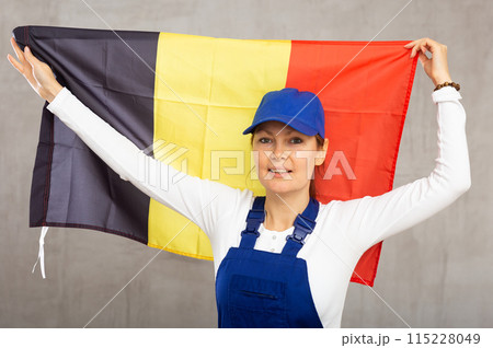 Smiling adult woman in uniform holding Belgium flag 115228049
