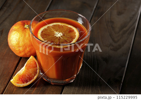 輪切りの果実も浮いているブラッドオレンジジュース 115229995