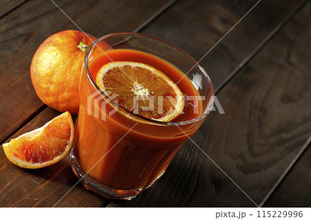 輪切りの果実も浮いているブラッドオレンジジュース 115229996