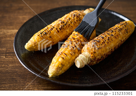 焼きとうもろこしにタレを塗る 115233301