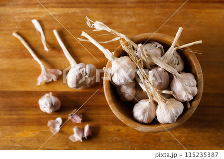 Ripe organic garlic clove and bulb on wooden background.  Close-up. Selective focus. 115235387