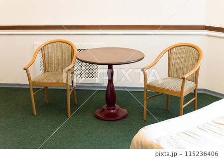 Small cramped hotel room with old furniture 115236406