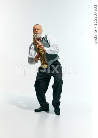 Engagement with music. Bearded musician informal attire playing saxophone energetically against white studio background. Engagement with music. Bearded musician informal attire playing saxophone energetically against white studio background. 115237933
