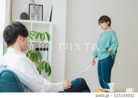 掃除をする女性とスマホをいじる男性 115238082