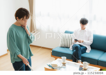 掃除をする女性とスマホをいじる男性 115238094