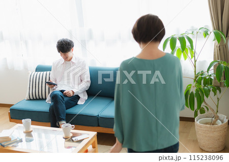 掃除をする女性とスマホをいじる男性 115238096
