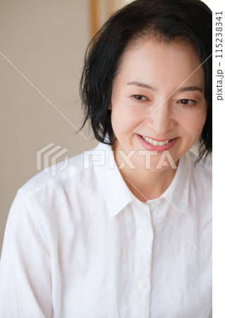 リビングで家族へ手紙を書いているミドル女性 115238341