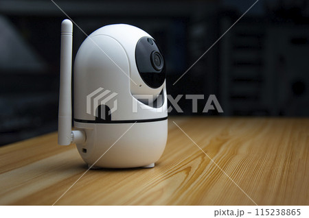 White IP camera placed on wooden floor 115238865