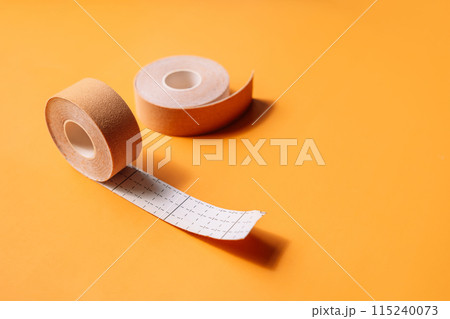 Adhesive tapes for the face in rolls on a yellow background 115240073