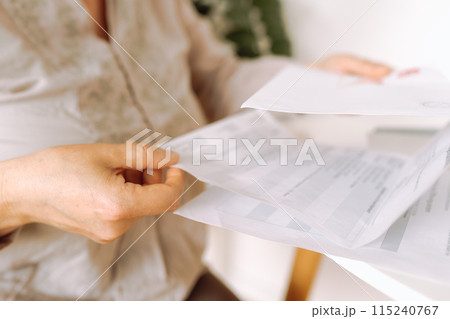 woman's hands holding an envelope with a letter 115240767