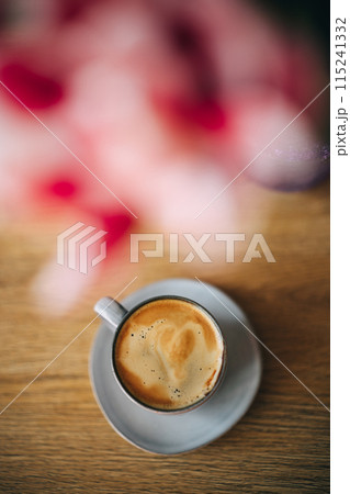 Spring tulips and cup of coffee on wooden table Spring tulips and cup of coffee on wooden table 115241332