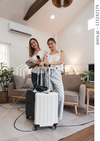 Two Young Women Preparing for Travel with Suitcases Indoors, Concept of Friendship and Summer Travel Two Young Women Preparing for Travel with Suitcases Indoors, Concept of Friendship and Summer Travel 115242174
