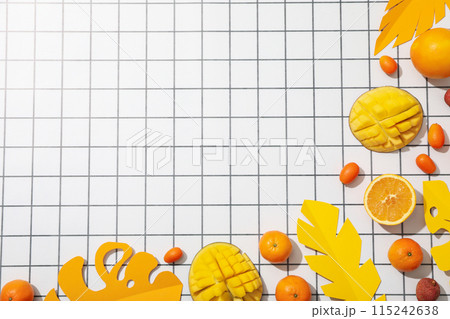 Tropical fruits and paper tropical leaves on light background, space for text Tropical fruits and paper tropical leaves on light background, space for text 115242638