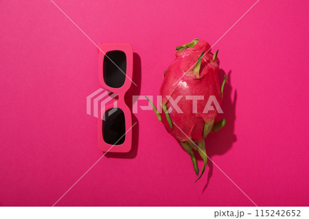 One whole dragon fruit and sunglasses on pink background, top view One whole dragon fruit and sunglasses on pink background, top view 115242652
