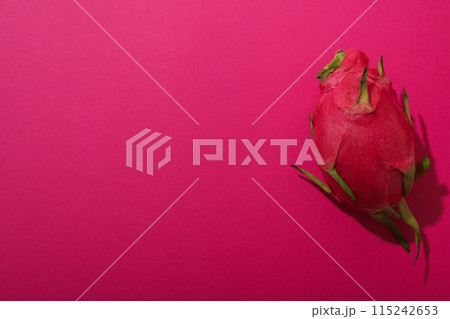 One whole dragon fruit on pink background, space for text One whole dragon fruit on pink background, space for text 115242653