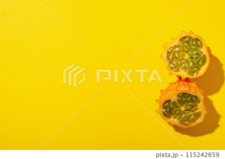 Two half of kiwano fruit on yellow background, space for text Two half of kiwano fruit on yellow background, space for text 115242659