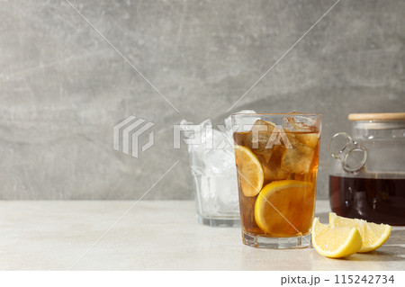 A glass of cold tea with ice and an orange A glass of cold tea with ice and an orange 115242734