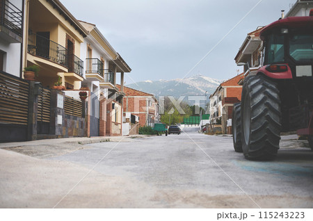 View of beautiful luxury cottages and villas in the city of Quesada of the region of Jaen in Spain. A partial view of tractor parked on the road. The province of Jaen. Olive paradise 115243223