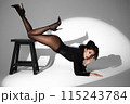 Beautiful woman in retro style in a black bodysuit and a bow in her hair in full length posing on a gray background. Beauty of body and face 115243784
