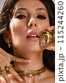 Beautiful tanned woman with smoky makeup, gold jewelry and ice. Beauty face. 115244260