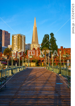 Dark wood pier with sunrise striking Transamerica Pyramid and other buildings Dark wood pier with sunrise striking Transamerica Pyramid and other buildings 115245523