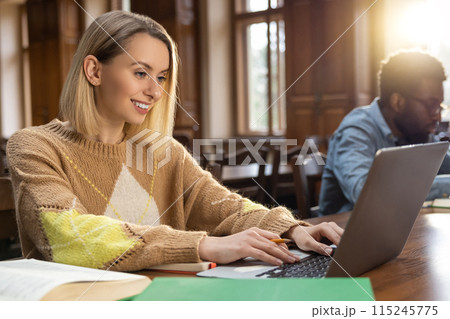 Young man and woman studying in the library ad looking focused 115245775