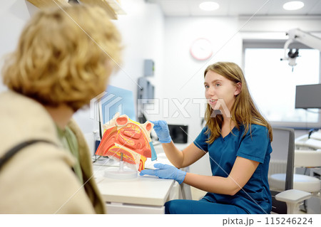 The otolaryngologist explains to the patient about his illness at the appointment. A professional ENT doctor demonstrates a model of the human nose. Treatment of inflammation disease of nose. The otolaryngologist explains to the patient about his illness at the appointment. A professional ENT doctor demonstrates a model of the human nose. Treatment of inflammation disease of nose. 115246224
