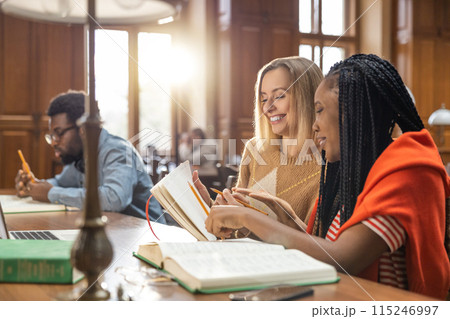 Group of students studying in the library together Group of students studying in the library together 115246997
