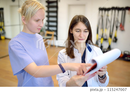 The rehab doctor conducts the patient's appointment in the gym. Before starting an individual session, the rehabilitologist make a patient survey and fills out a questionnaire. 115247007