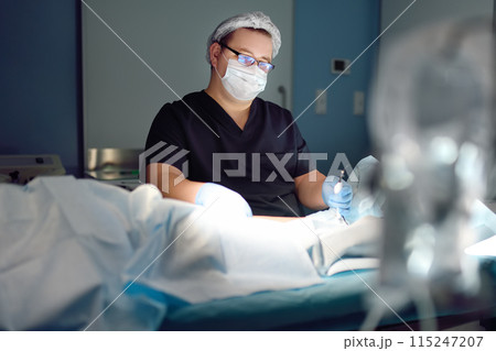 Professional vascular surgeon is in the operating room of the clinic during vein surgery. Phlebectomy. Modern technology of deep vein thrombosis treatment. 115247207