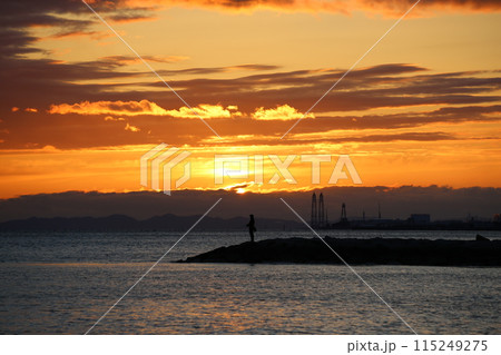 海に沈む夕日と釣りをする人 115249275