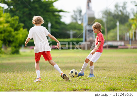 Child playing football. Kids play soccer. 115249516