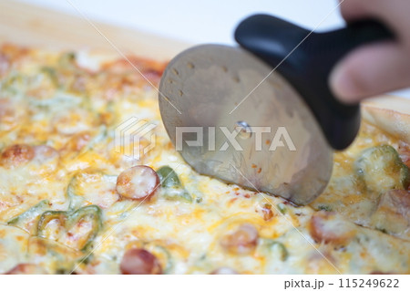 自宅で手作りピザをカッターで切る主婦 自宅で手作りピザをカッターで切る主婦 115249622