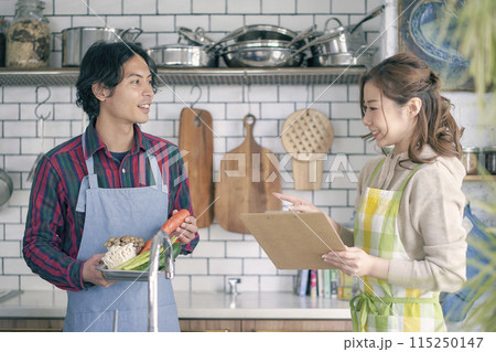 キッチンに立つ若い夫婦 キッチンに立つ若い夫婦 115250147