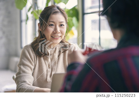カフェで談笑するカップル 115250223