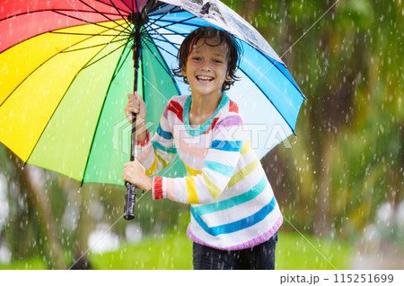Child playing in rain. Kid jumping in puddle. Child playing in rain. Kid jumping in puddle. 115251699