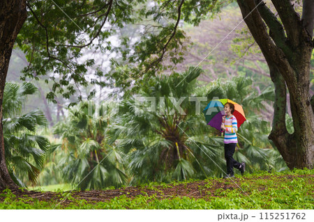 Child playing in rain. Kid jumping in puddle. Child playing in rain. Kid jumping in puddle. 115251762