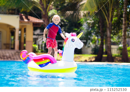 Child on unicorn float in swimming pool. Kids swim Child on unicorn float in swimming pool. Kids swim 115252530
