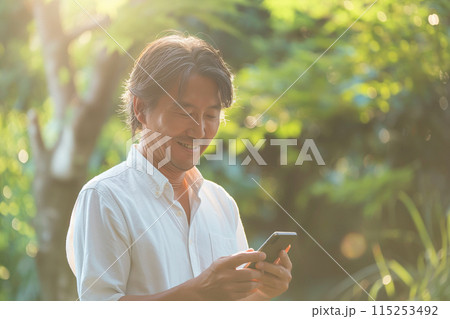 外でスマホを操作するビジネスマン 115253492