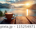 cup of coffee with lake and mountains view on the background at sunrise or sunset 115254971