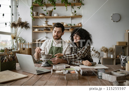 Man and woman creating pottery in studio during online class 115255597