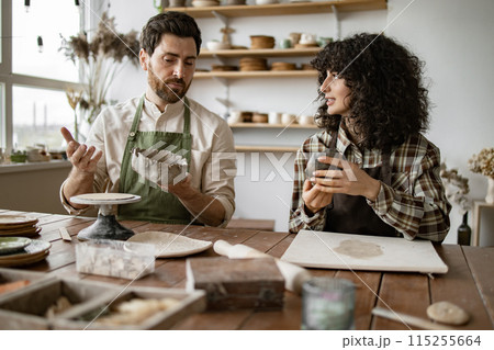 Mature man and woman crafting pottery in art studio 115255664
