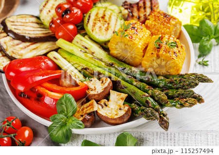 Assorted grilled vegetables on a plate, showcasing a colorful meal Assorted grilled vegetables on a plate, showcasing a colorful meal 115257494