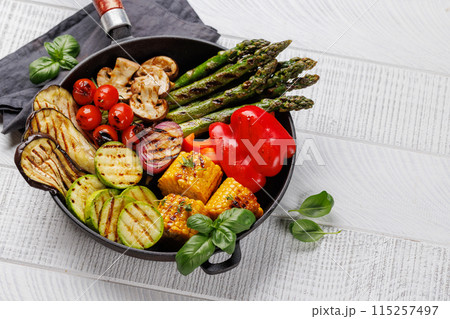Assorted grilled vegetables on a frying pan, showcasing a colorful and healthy meal Assorted grilled vegetables on a frying pan, showcasing a colorful and healthy meal 115257497