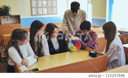 Students in physics class spin Newton's multicolored disk. 115257896