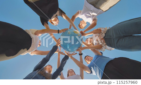 Friends holding a geographical globe in their hands. The concept of keeping the world safe. 115257960